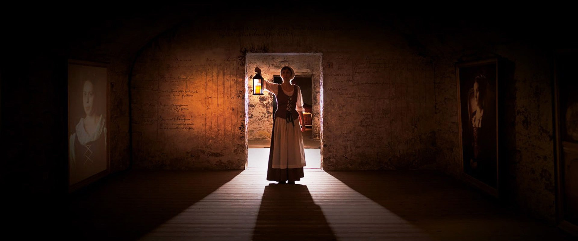 Continuum banner with a person standing in a door frame holding a candle light