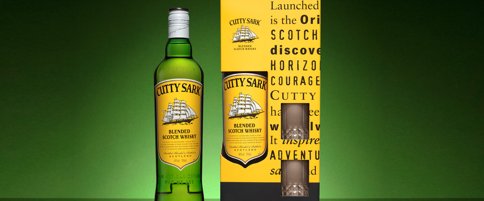 Display of Cutty Sark packaging with two glasses and a bottle of Cutty Sark with a bottle of Cutty Sark next to the package.