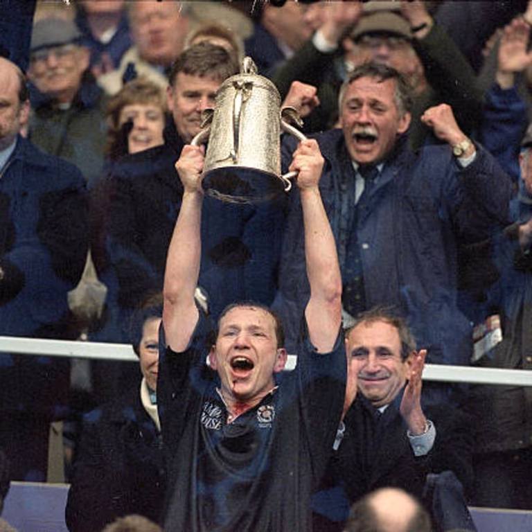 Andy Nicol playing for Scotland holding up a cup