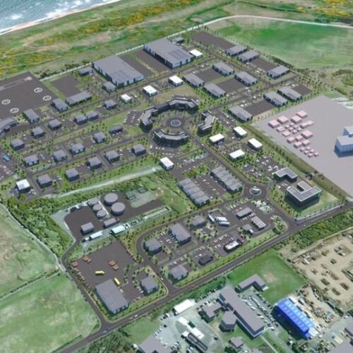 An aerial digital rendering of a large, organized business park development near a coastline, showing numerous grey commercial buildings, parking lots, and green landscaping.