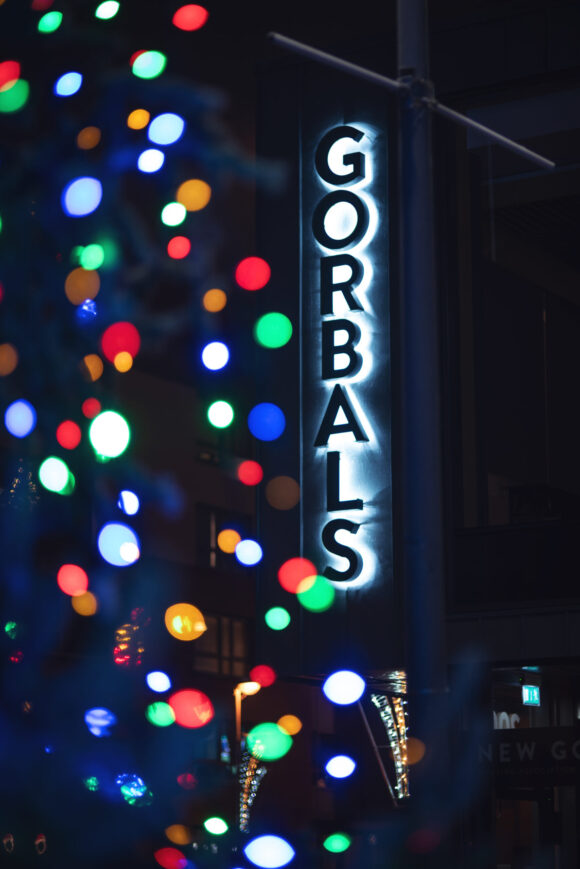 Colourful Christmas tree lights with sign saying Gorbals lit up in background