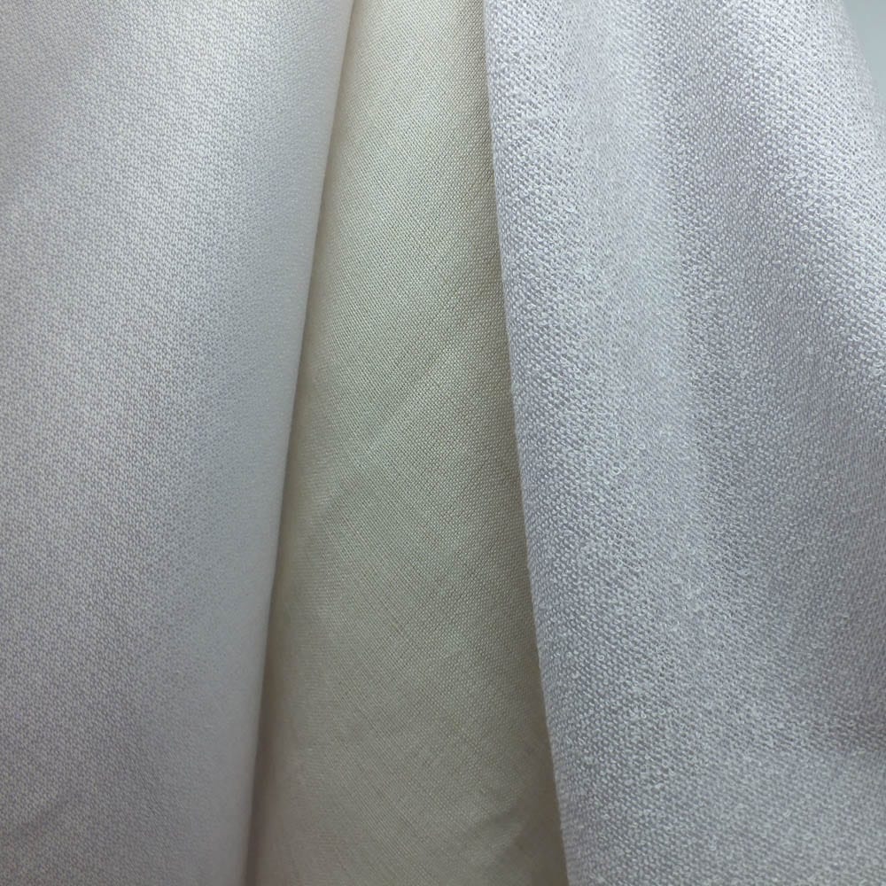 Sencillo Collection Cover Image - three draped fabrics in soft neutral tones, including two light grey textured weaves and a smooth cream fabric in the centre.