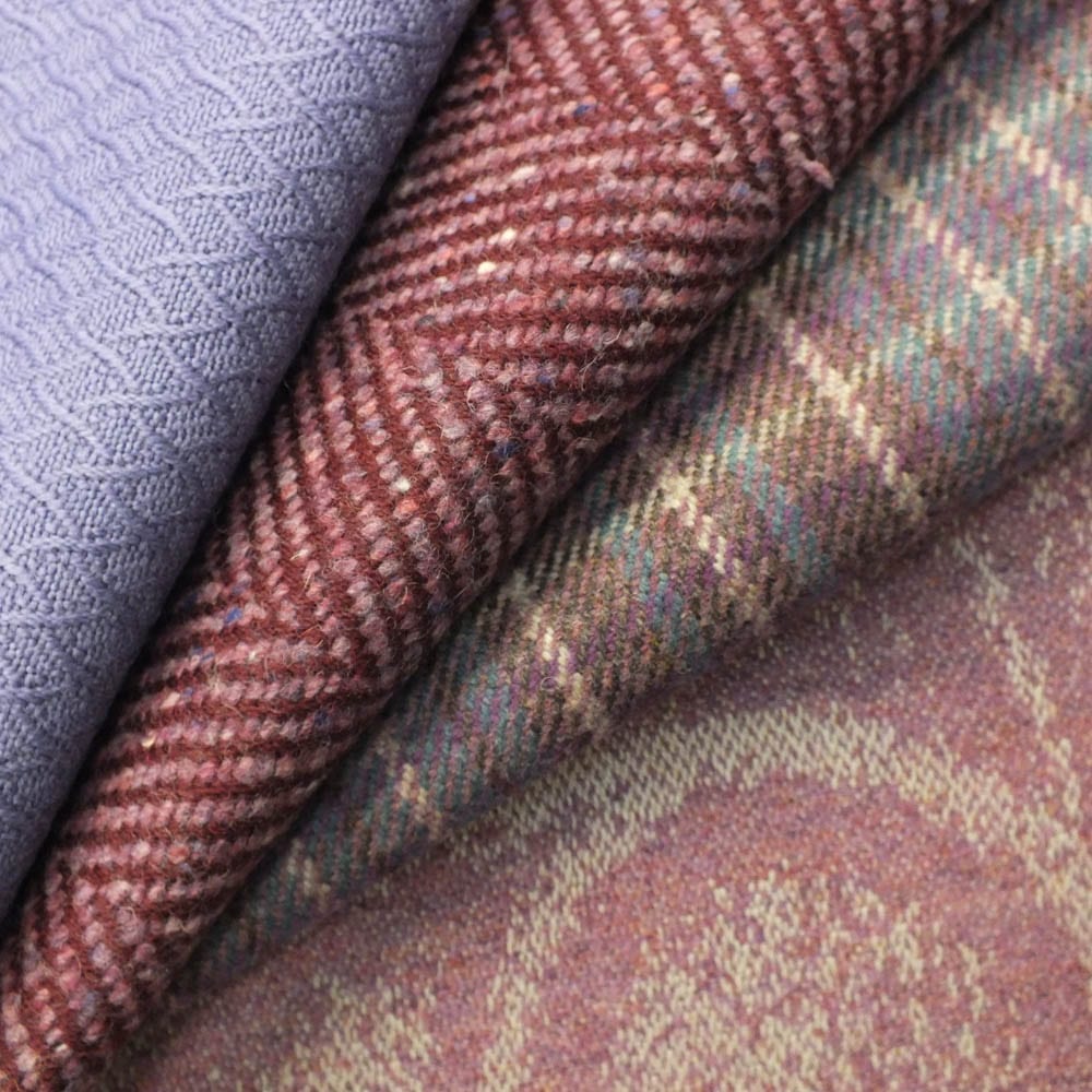 Rosslyn Park Collection Cover Image - a selection of folded woven fabrics in muted tones, including a lavender geometric weave, a burgundy herringbone, a green and brown check, and a soft paisley pattern in dusty pink.