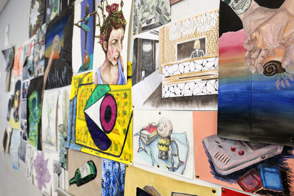 collection of artwork pinned onto wall
