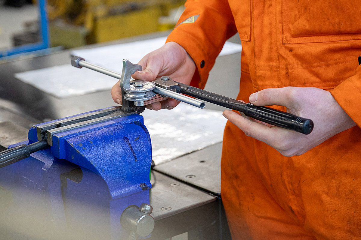 student working with tools and piping
