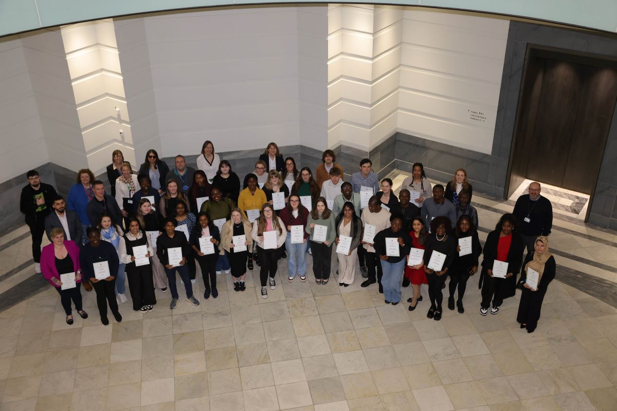 The 2025 bp student tutors standing in a semi-circle and holding certificates.