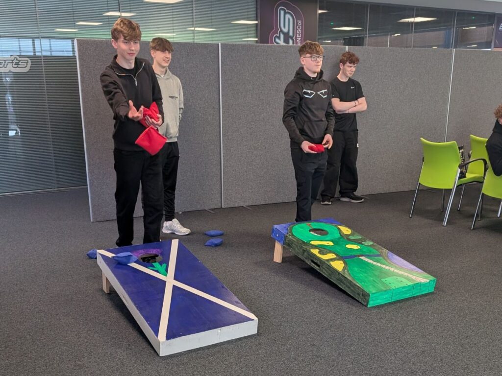 Four Foundation Apprentices playing cornhole.