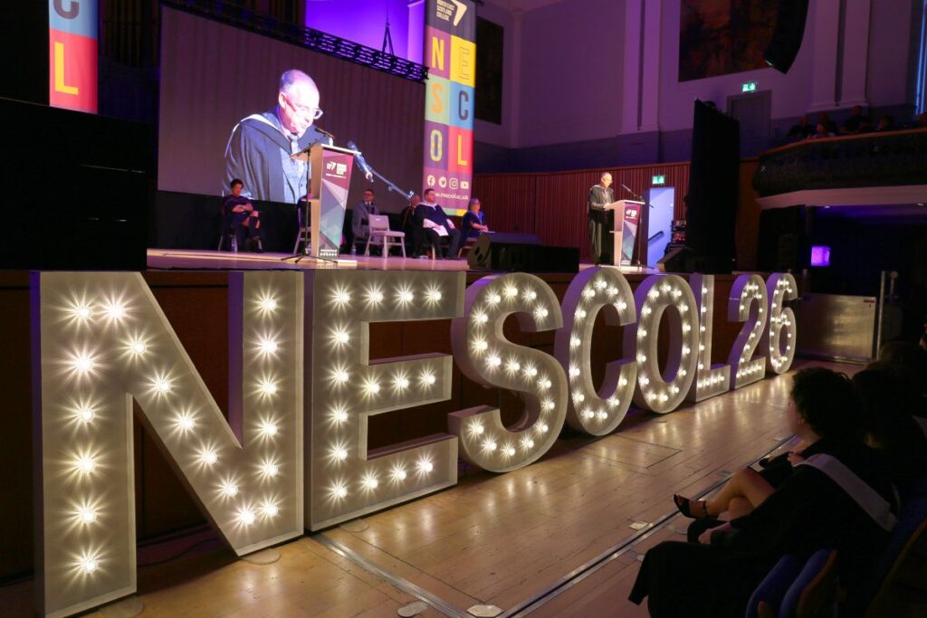 Stage at graduation with light up letters that spell NESCOL 26