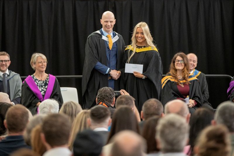 Taylor receiving her award on stage at graduation.