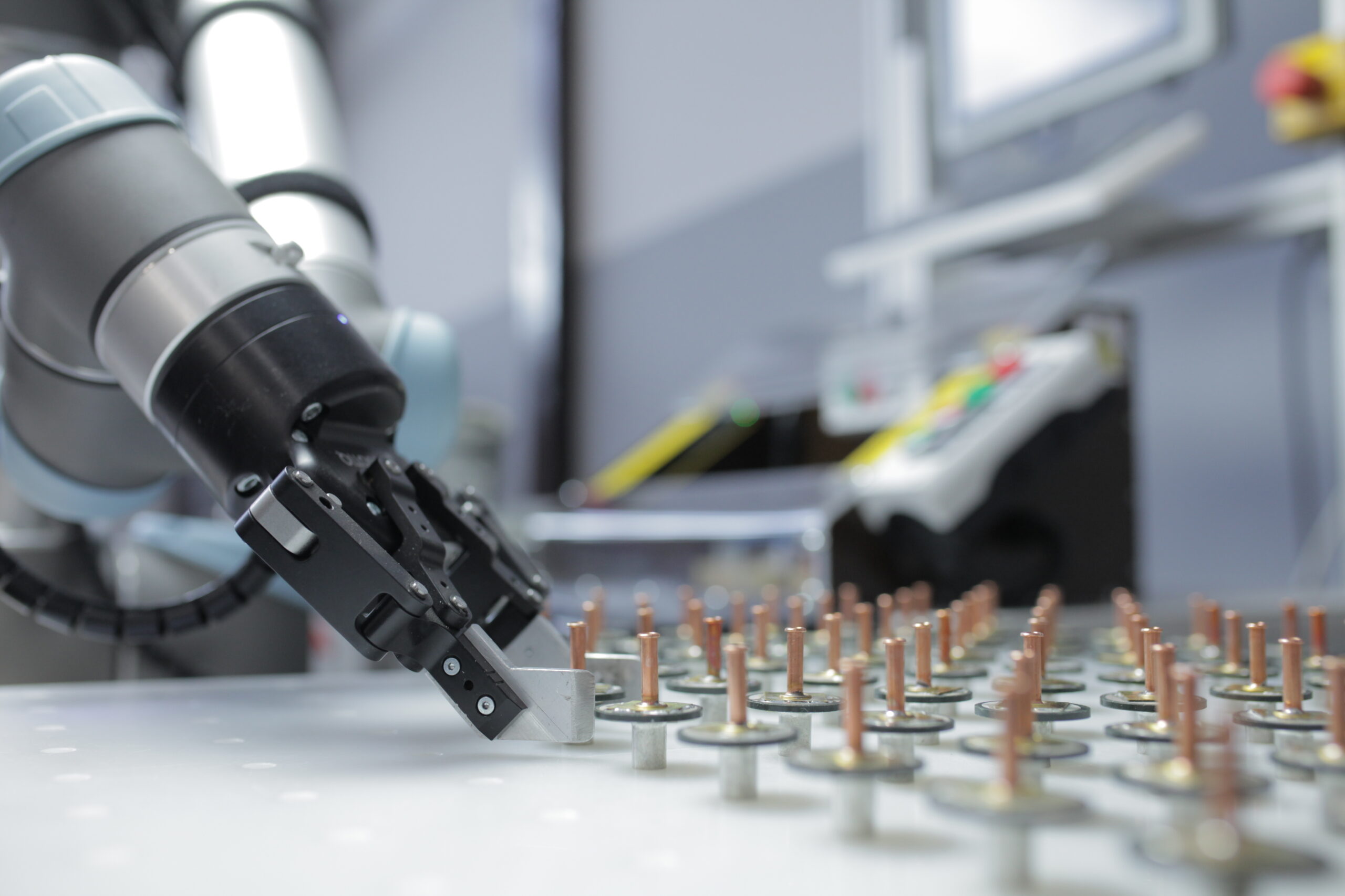 A Universal Robots cobot picking up a small item for a machine