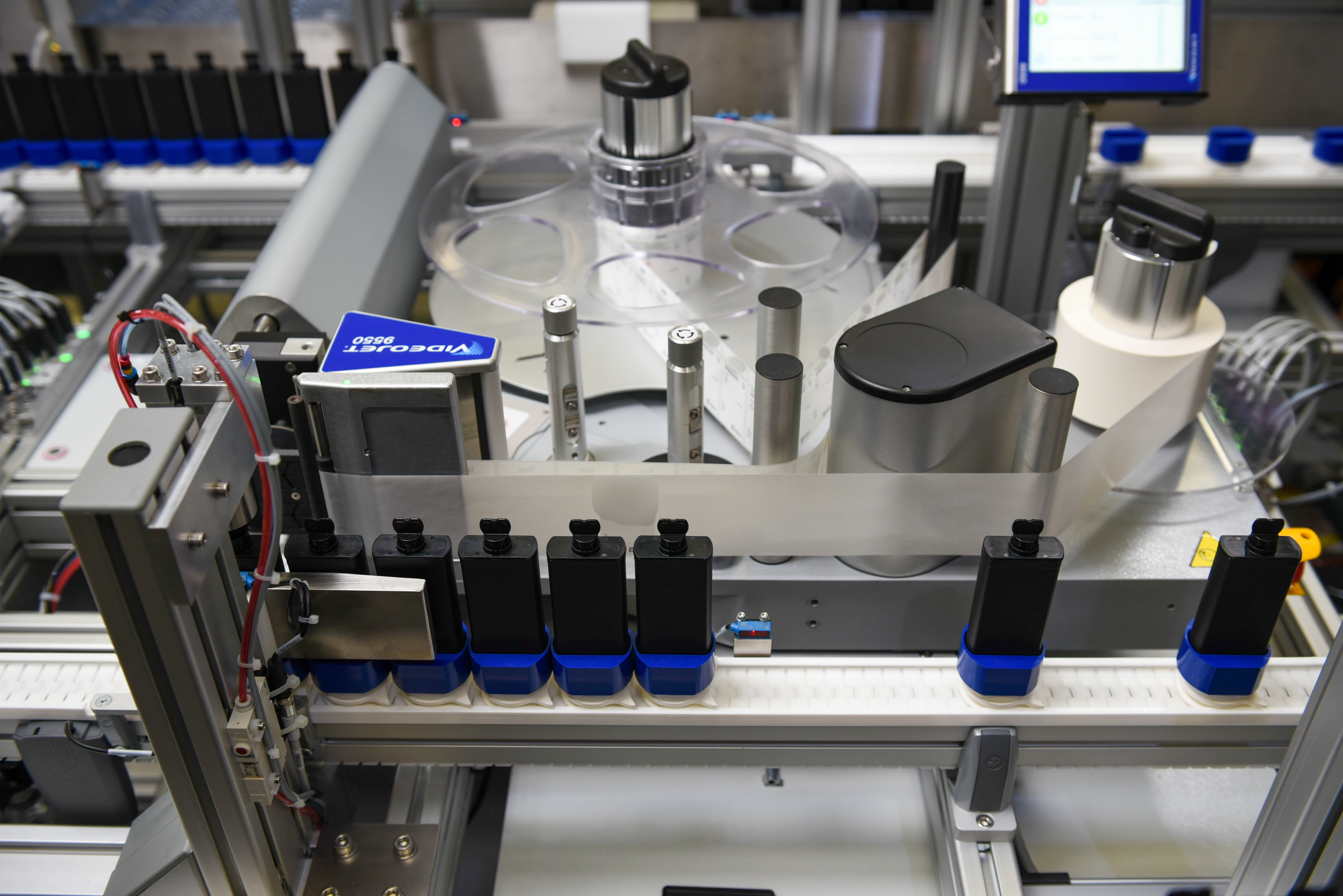 Containers in pucks on a conveyor