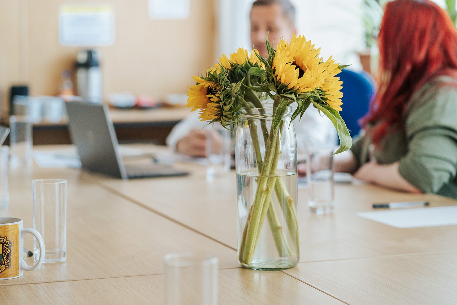 The Circle Dundee's training room with a vase of sunflowers and two tenants having a meeting.