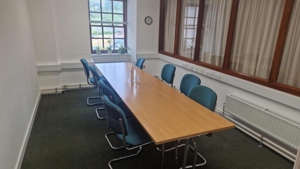 photo of one the meeting spaces in the office. the space fits a table with 8 chairs around it