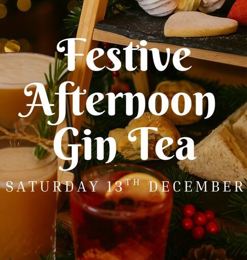 A dark, warm, and inviting promotional graphic for a "Festive Afternoon Gin Tea" scheduled for "SATURDAY 13TH DECEMBER." The large, decorative white text is overlaid on a soft-focus background of festive items. The background includes a tiered stand featuring sweet and savory items like a scone or shortbread and a sandwich, surrounded by Christmas decorations like fir branches, red berries, and a pine cone. The foreground prominently features two festive drinks: a light-colored, creamy cocktail garnished with rosemary on the left, and a dark red drink, possibly a mulled gin, with fruit and spices on the right.