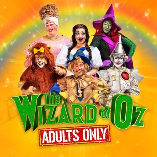 A poster for a pantomime show titled "The Wizard of Oz: Adults Only." Six performers in colorful costumes and exaggerated makeup are posing in a group, set against a vibrant yellow-orange background with a rainbow arc above them. The characters include an adult-panto version of the Dame, Dorothy, the Wicked Witch of the West, the Cowardly Lion, the Scarecrow, and the Tin Man.