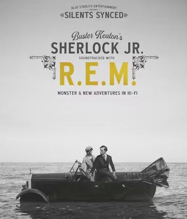 A black and white image of two people, a man in a suit and a woman in a hat, sitting in a convertible car that appears to be floating on water, with a light gray sky and horizon in the background. The text reads "SILENTS SYNCED Buster Keaton's SHERLOCK JR. SOUNDTRACKED WITH R.E.M! MONSTER & NEW ADVENTURES IN HI-FI."
