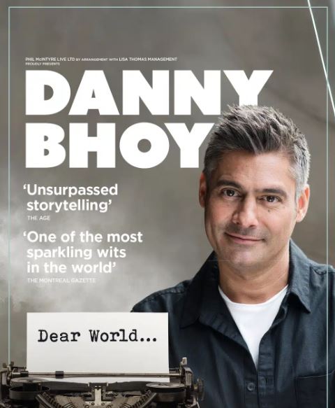 A promotional poster for comedian Danny Bhoy, featuring a close-up portrait of the smiling performer. To his left, a white card in a vintage typewriter reads "Dear World...". The poster includes large bold text of his name and praise from The Age for his "unsurpassed storytelling" and from The Montreal Gazette calling him one of the "most sparkling wits in the world."