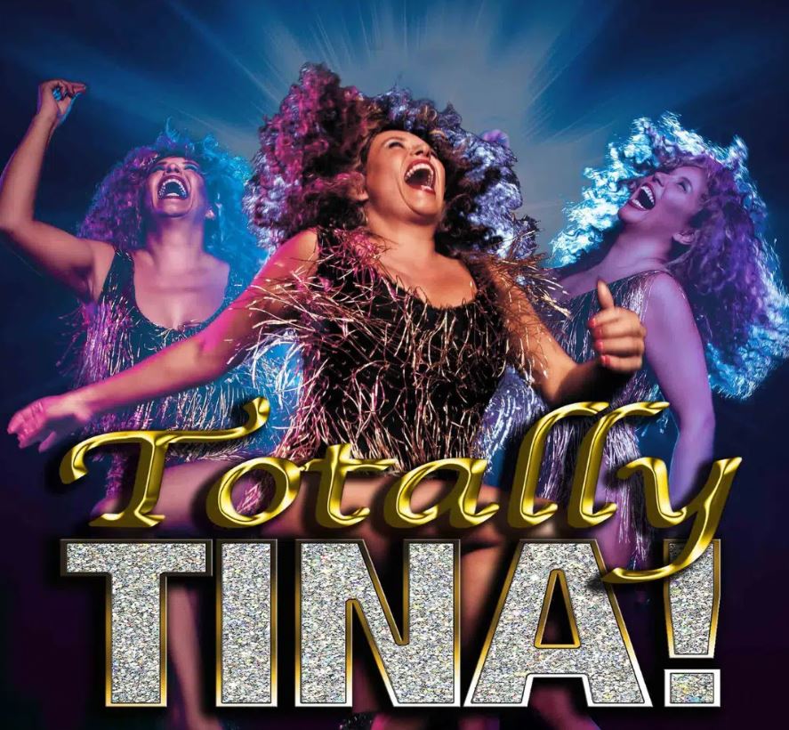 A promotional poster for the "Totally Tina" tribute show, featuring a central performer and two backup singers with large, styled hair, celebrating on stage with bright lighting. The image features stylized, glittering gold and silver text that reads "Totally TINA!".