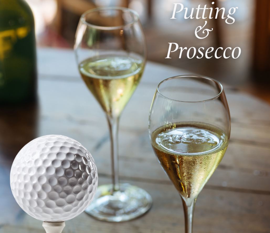 A promotional image featuring two elegant glasses of sparkling wine on a rustic wooden table, with a golf ball on a tee in the lower-left foreground. The white serif text in the upper-right corner reads "Putting & Prosecco."