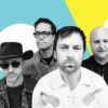 Promotional band photograph featuring four musicians posed against a bold blue, yellow and white graphic background, with one person in a cowboy hat and sunglasses and the others dressed in casual shirts and jackets.